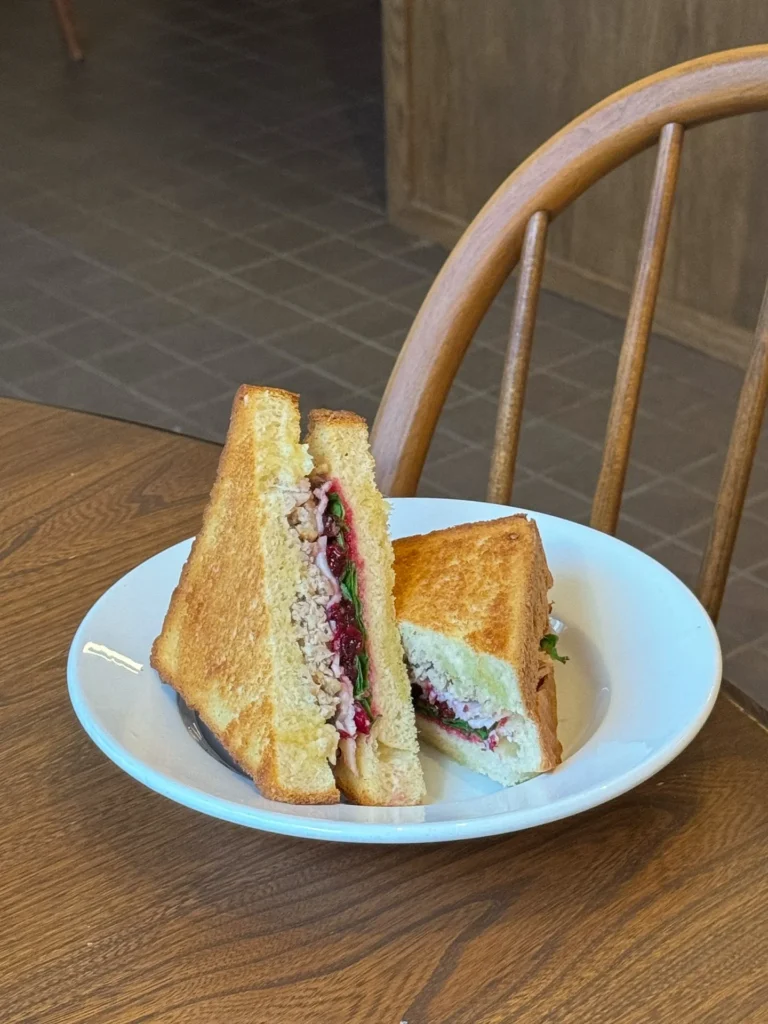 Kotona&Co: Delicious sandwich cut in half on plate.